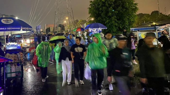 HUJAN - Sejumlah Bobotoh tiba di Stadion GBLA di tengah hujan. Mereka datang untuk menyaksikan Persib Bandung vs Persita Tangerang, Minggu (22/2/2026) malam.