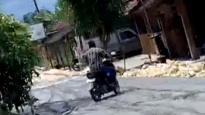 LINTASI JALAN COR - Warga Palon, Agus Sutrisno, saat melintasi jalan cor yang kondisinya masih basah, Jumat (20/2/2026). (Tangkapan Layar)