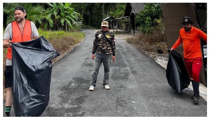 MEMBERSIHKAN - Warga membersihkan sampah di sejumlah titik Desa Wisata Sei Gohong dalam kegiatan Bersih-bersih 2.0, Sabtu (21/2/2026).