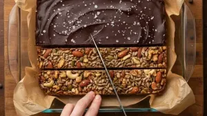 Cutting chocolate nut bars into slices in baking dish.
