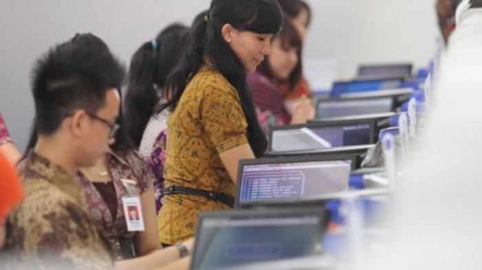 KARYAWAN SWASTA - Karyawan Bank BCA menggunakan baju batik saat melayani nasabah di Kantor Bank BCA, Jalan Sudirman Pekanbaru, Rabu (2/10/2013)