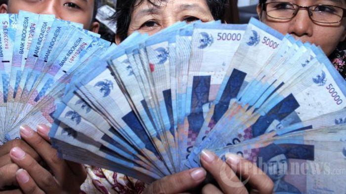 UANG - Warga Jakarta memperlihatkan uang dari hasil berdagang, Sabtu (21/12/2013)