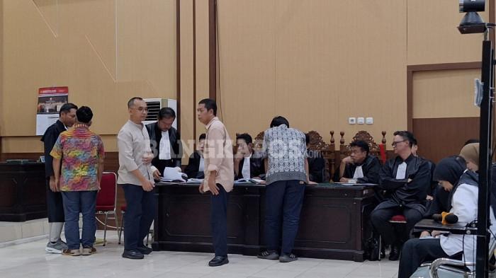 SIDANG KORUPSI BWS-- Kelima terdakwa saat berdiskusi dengan tim penasihat hukumnya masing-masing, di ruang sidang Garuda Pengadilan Negeri Pangkalpinang, Kamis (18/12/2025) (Bangkapos.com/Adi Saputra).