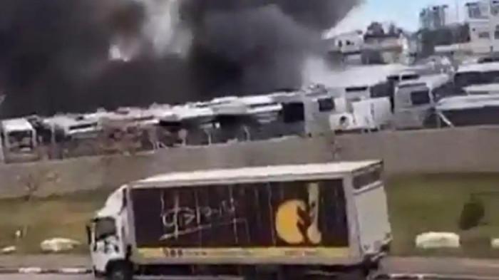 ISRAEL SERANG IRAN — Sejumlah armada bus hangus terbakar dengan kepulan asap hitam pekat di Holon, Israel, Sabtu (28/2/2026). Ledakan hebat di jantung metropolitan Tel Aviv ini terjadi sesaat setelah militer Israel melancarkan serangan udara berskala besar ke sejumlah wilayah Iran.