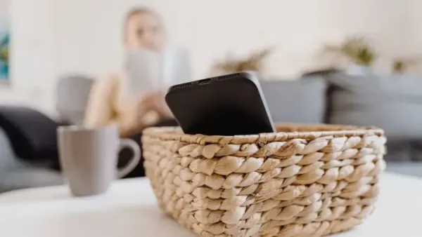 a mobile in wooden box and a woman sitting in background