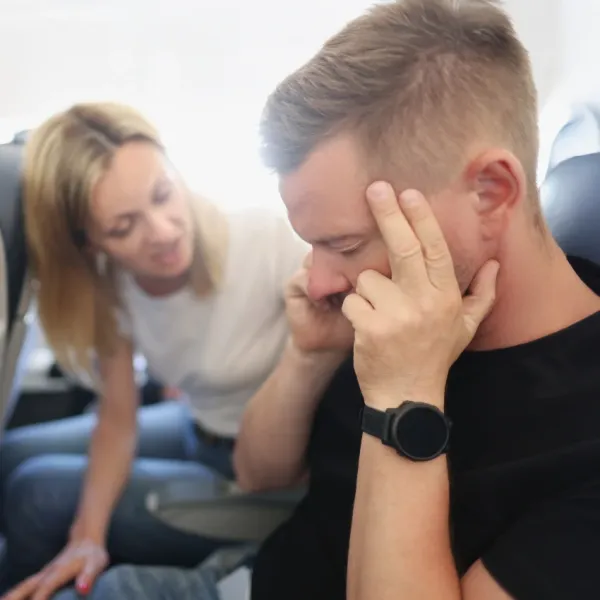man blocking out rude passenger on plane