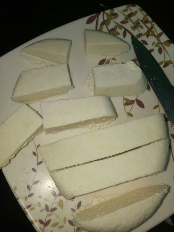 This may contain: slices of cheese on a plate with a knife