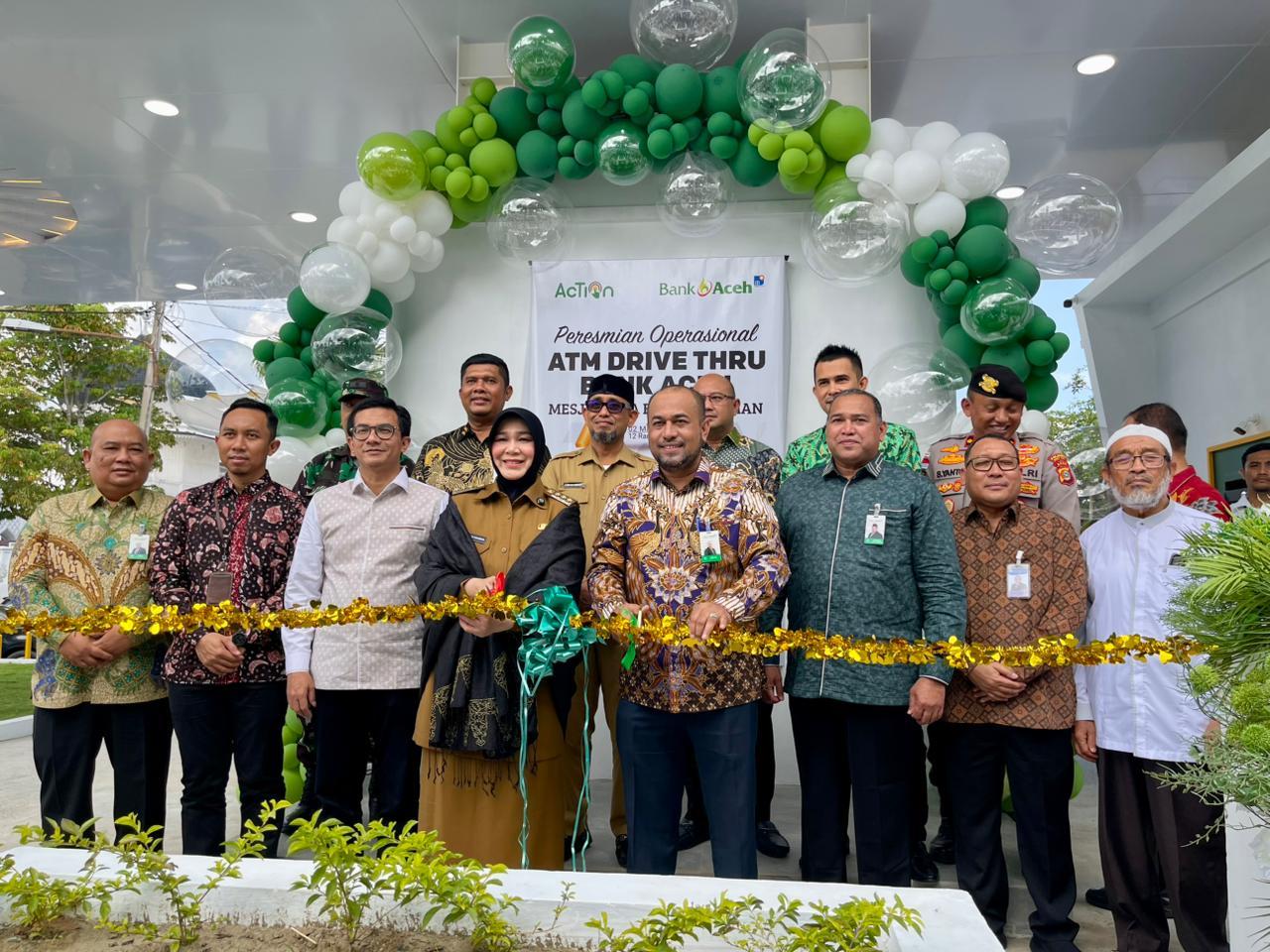 Wali Kota Banda Aceh, Illiza Sa'aduddin Djamil disaksikan Dirut Bank Aceh Fadhil Ilyas sedang mengambil uang dari ATM Drive Thru Bank Aceh di samping Masjid Raya Baiturrahman, Banda Aceh, Senin (2/3/2026).