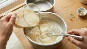 Slowly fold the thandai milk mixture into the whipped cream to keep the mixture light and fluffy.