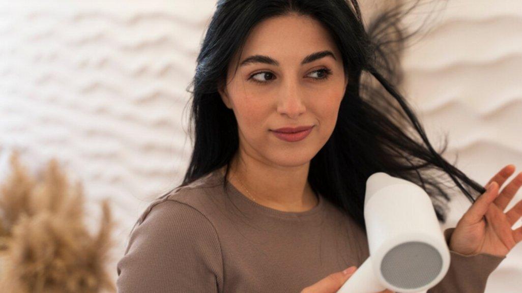 Ilustrasi mengeringkan rambut dengan hair dryer.