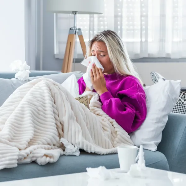 blonde woman home sick on the couch