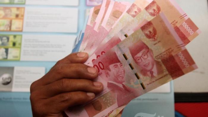 UANG - Warga menunjukkan uang kertas rupiah baru tahun emisi 2016 usai melakukan penukaran uang di Blok M Square, Jakarta, Senin (19/12/2016)