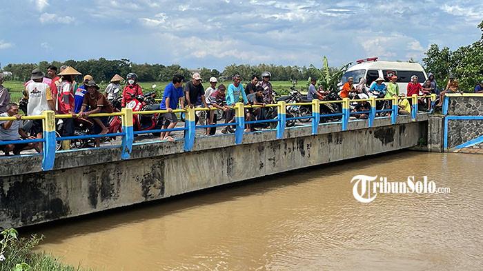 PENCARIAN KORBAN - Warga tengah menyaksian pencarian Saifulloh Yusuf Arfan (8) di sungai irigasi Desa Kenokorejo, Kecamatan Polokarto, Kabupaten Sukoharjo, Kamis (5/3/2026) siang. Korban diketahui bermain bersama temannya di aliran sungai irigasi usai melaksanakan salat Dzuhur. Namun lantaran diduga tidak bisa berenang, korban akhirnya tenggelam.