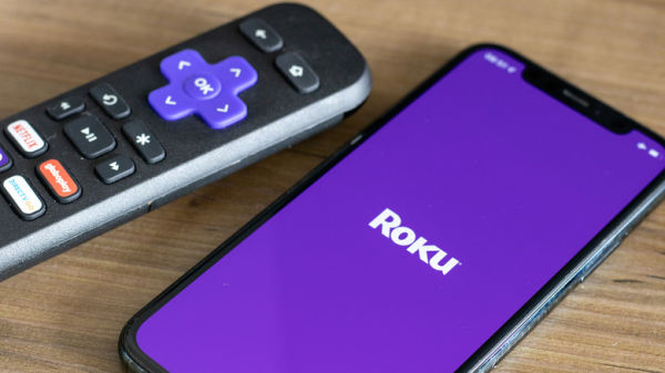 Roku ॲप उघडलेल्या फोनच्या बाजूला एक Roku रिमोट