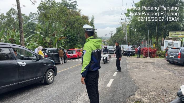 ARUS LALU LINTAS- Petugas SatLantas Polres Padang Panjang saat mengatur arus lalu lintas di jalur Lembah Anai, Kabupaten Tanah Datar, Sumbar, Minggu (15/2/2026) pagi. Kasat Lantas Polres Padang Panjang, AKP Pifzen Finot sebut arus lalin sudah dibuka dua arah usai sempat diberlakukan buka tutup.