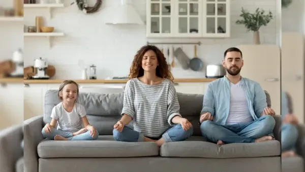 a family of three on sofa meditating cheerfully