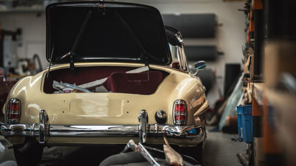 Classic Mercedes in repair shop with trunk open, rear-view