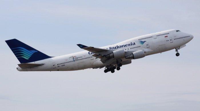 Ilustrasi pesawat Garuda Indonesia yang sedang mengudara.