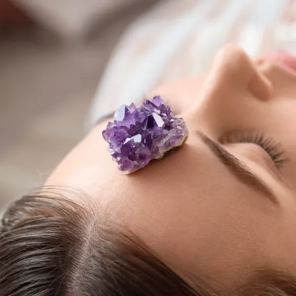 woman doing crystal healing with an amethyst