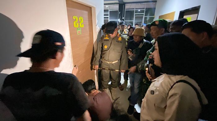RAZIA - Kasatpol PP Kota Bengkulu, Sahat Marulitua Situmorang bersama TNI-Polri, saat menunggu penjagan penginapan membuka pintu kamar di salah satu penginapan di kawasan Suka Merindu, Kota Bengkulu, Rabu (4/3/2026). Razia Penyakit Masyarakat (Pekat) di Bengkulu, aparat temukan pasangan di kamar penginapan dan dugaan praktik prostitusi online.