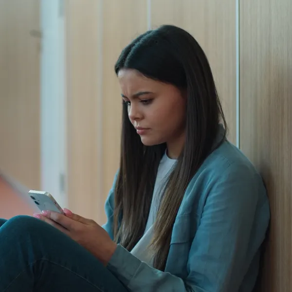 upset teen girl using smartphone
