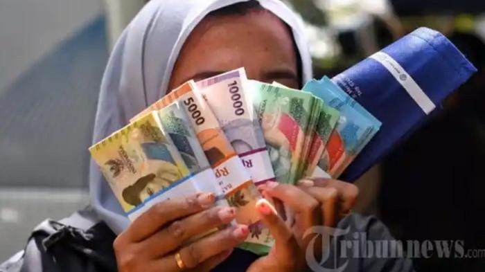 UANG BARU - Warga menukarkan uang di mobil kas keliling Bank Indonesia Malang di Taman Merjosari, Kota Malang, Jawa Timur, Kamis (19/2/2026).