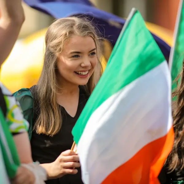 woman waving irish flag respecting Irish tradition and customs