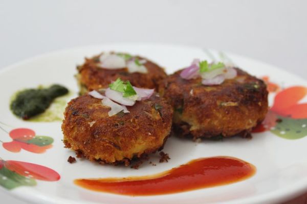 This may contain: three crab cakes on a white plate with sauce