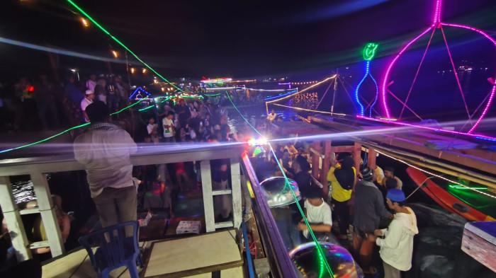 TAKBIRAN - Suasana Takbiran Laut Idul Fitri 1447 Hijriah. Kapal nelayan saat melintas di perairan Teluk Ambon, Jumat (20/3/2026).