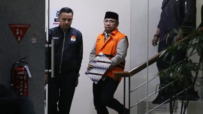DITAHAN KPK - Mantan Menteri Agama Yaqut Cholil Qoumas mengenakan rompi oranye saat digiring menuju mobil tahanan usai menjalani pemeriksaan di Gedung Merah Putih KPK, Jakarta, Kamis (12/3/2026). Yaqut resmi ditahan atas dugaan manipulasi kuota haji tambahan tahun 2023-2024 yang merugikan negara sebesar Rp622 miliar dan merampas hak ribuan jemaah reguler.