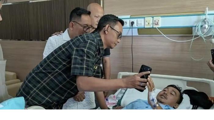 TANGGUNG JAWAB: Perwakilan keluarga pengusaha rokok HS, Muhammad Suryo (tengah, memegang gawai), memfasilitasi panggilan video untuk menyampaikan permohonan maaf secara langsung kepada Abdullah yang tengah menjalani perawatan di RSUD Wates, Kabupaten Kulon Progo, Daerah Istimewa Yogyakarta, Selasa (3/3/2026).