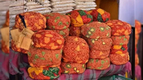 Vibrant Rajasthani pagdis (traditional turbans) with bandhani patterns stacked in a market.