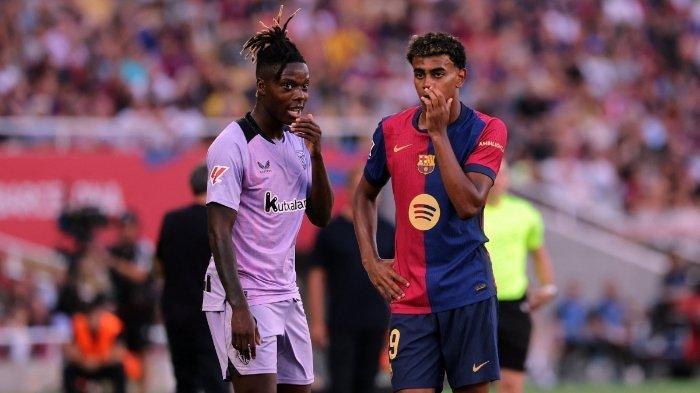 Pemain depan Athletic Bilbao Nico Williams (kiri) dan pemain depan Barcelona asal Spanyol #19 Lamine Yamal berbincang selama pertandingan sepak bola liga Spanyol antara FC Barcelona dan Athletic Club Bilbao di Estadi Olimpic Lluis Companys di Barcelona pada tanggal 24 Agustus 2024.