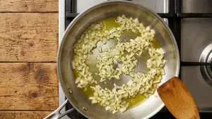 Heat olive oil in a shallow pan and add finely chopped onion. Cook it until it turns light golden and releases a mild aroma.