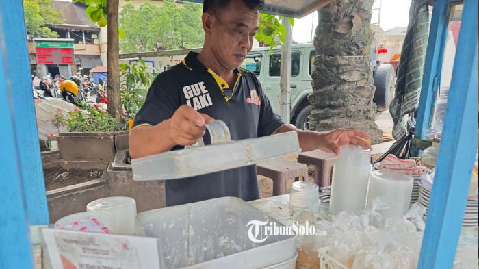 TAHOK PAK CITRO - Pemilik Tahok Pak Citro generasi kedua, Sentot saat melayani pelanggan. Tahok merupakan kuliner khas Solo dengan tekstur lebih halus dibanding wedang tahu atau kembang tahu dari daerah lain.