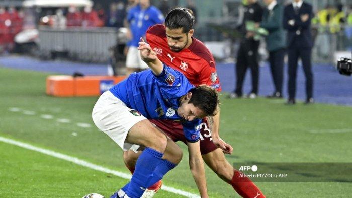 Pemain depan Italia Federico Chiesa (tengah) dan pemain belakang Swiss Ricardo Rodriguez mengejar bola selama pertandingan sepak bola Grup C kualifikasi Piala Dunia Qatar 2022 antara Italia dan Swiss pada 12 November 2021 di stadion Olimpiade di Roma.