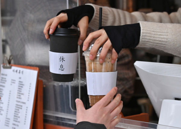 जानेवारी 2023 मध्ये सेऊलमधील कॅफेमध्ये एक कर्मचारी ग्राहकाला गरम आणि कोल्ड कॉफी ड्रिंक देत आहे. एएफपी द्वारे फोटो