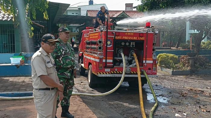 DITERJANG BANJIR - Kasi Ekbang Kelurahan Cibubur, Heru Kristianto saat proses kerja bakti di SMAN 99 Jakarta, Ciracas, Jakarta Timur, Senin (23/3/2026). TRIBUNJAKARTA.COM/BIMA PUTRA