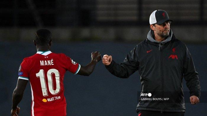 Tinju manajer Liverpool Jerman Jurgen Klopp (kanan) menabrak striker Liverpool Senegal Sadio Mane pada akhir pertandingan sepak bola perempat final leg pertama Liga Champions UEFA antara Real Madrid dan Liverpool di stadion Alfredo di Stefano di Valdebebas di pinggiran Madrid pada April 6, 2021.GABRIEL BOUYS / AFP