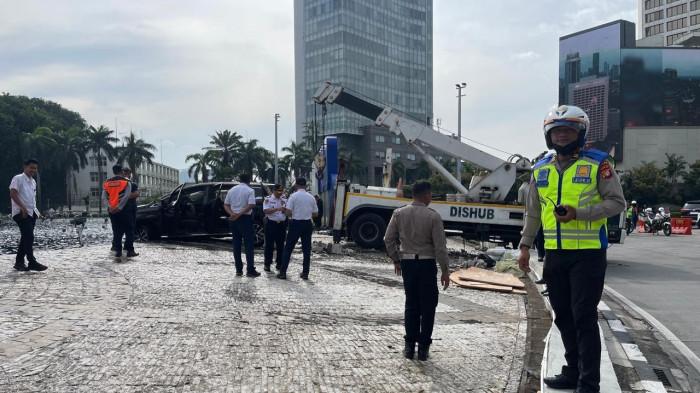 KECELAKAAN DI BUNDARAN HI - Insiden kecelakaan hari ini di Bundaran Hotel Indonesia (HI), mobil berkelir hitam tabrak pembatas nyebur kolam, Rabu (25/3/2026) dini hari. Penampakan mobil dievakuasi petugas Dishub DKI.