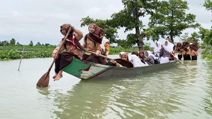 BANJIR LAMONGAN -  Para siswa di Kabupaten Lamongan, Jawa Timur, naik perahu untuk berangkat ke sekolah, Selasa (10/3/2026). Selama 4 bulan banjir akibat luapan Bengawan Jero di Lamongan masih mengepung 44 desa di lima kecamatan.