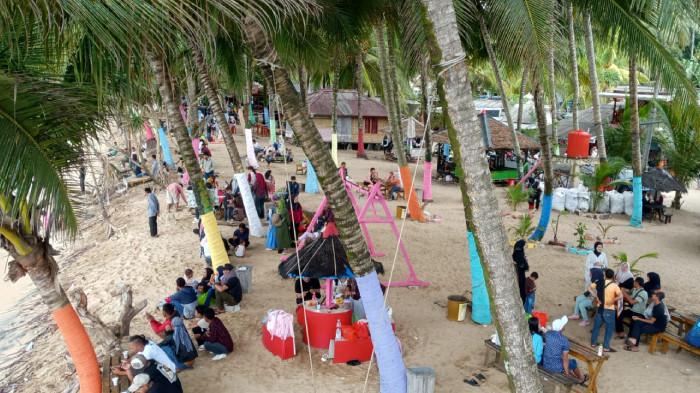 WISATA PANTAI -  Suasana pantai Kelapa Warna di Kecamatan Cihara, Kabupaten Lebak, Banten, saat momen lebaran Idulfitri, Rabu (25/3/2026).