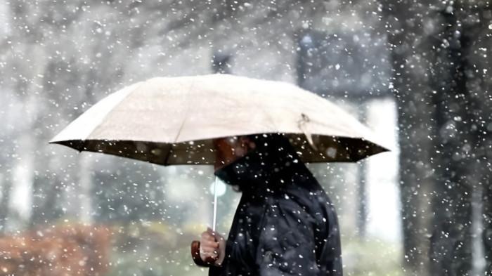 CUACA BURUK- Ilustrasi seorang pria dengan menggunakan payung sedang melintasi kawasan yang dilanda cuaca buruk.