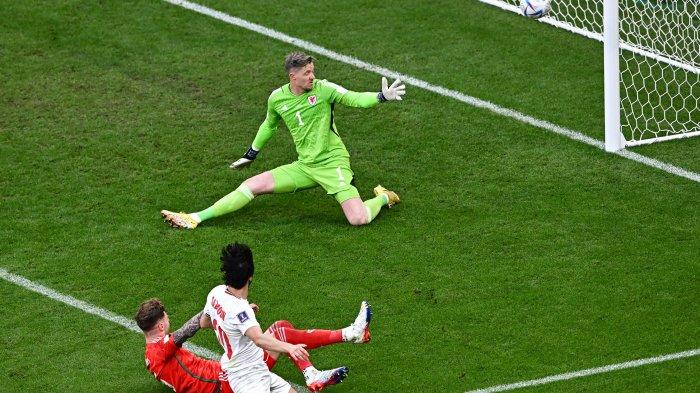 Penyerang Timnas Iran, #20 Sardar Azmoun (depan, bawah) melakukan tembakan yang membentur tiang gawang melewati penjaga gawang Timnas Wales, #01 Wayne Hennessey (atas) yang berusaha melakukan penyelamatan untuk mengamankan bola dalam laga sepak bola Grup B Piala Dunia 2022 Qatar antara Wales melawan Iran di Stadion Ahmad Bin Ali, di Al-Rayyan, sebelah barat Doha, Qatar, Jumat (25/11/2022) waktu setempat. AFP/ANNE-CHRISTINE POUJOULAT