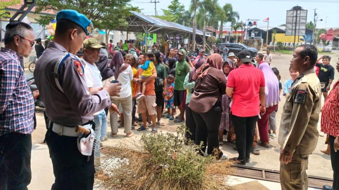 PENYAPU KOIN - Petugas Polsek Sukra saat mengamankan penyaluran kompensasi bagi para penyapu koin Jembatan Sewo di Kantor Kepala Desa Sukra, Kecamatan Sukra, Kabupaten Indramayu, Kamis (19/3/2026).