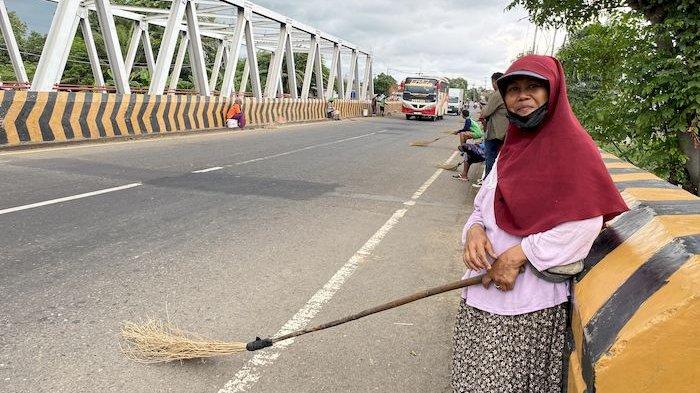 PENYAPU KOIN - Maskirah, penyapu koin di Jembatan Sewo perbatasan Subang-Indramayu di Jalur Pantura, Senin (24/3/2025)