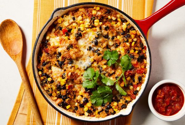 चीझी ब्लॅक बीन आणि क्विनोआ स्किलेट कॅसरोल रेसिपीच्या कास्ट आयर्न स्किलेटचे ओव्हरहेड दृश्य श्रेय: छायाचित्रकार: राहेल मारेक