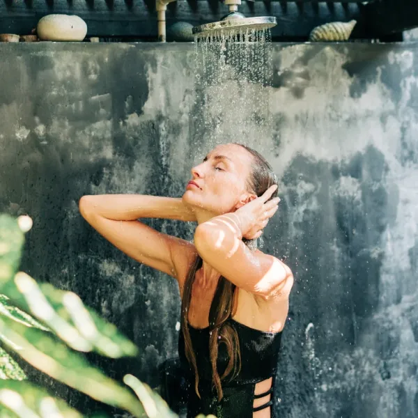 blonde woman using outdoor shower