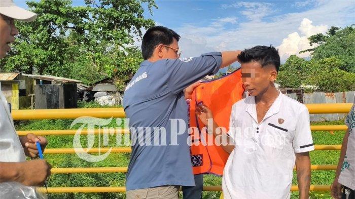 PUNGLI DI PADANG- Kepala Dishub Kota Padang, Ances Kurniawan, memasangkan rompi juru parkir resmi kepada inisial Z (27) di kawasan Pantai Padang, belakang Hotel Pangeran, Kecamatan Padang Utara, Kota Padang, Jumat (27/3/2026) sore.