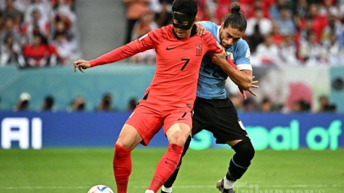 Bek Uruguay Martin Caceres berebut bola dengan gelandang Korea Selatan Son Heung-min selama pertandingan   Grup H Piala Dunia Qatar 2022 antara Uruguay dan Korea Selatan di Stadion Education City di Al-Rayyan, sebelah barat Doha pada 24 November, 2022.